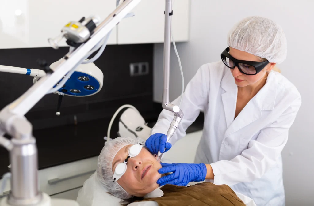 Clinician performing a facial skin treatment on a patient wearing protective eyewear